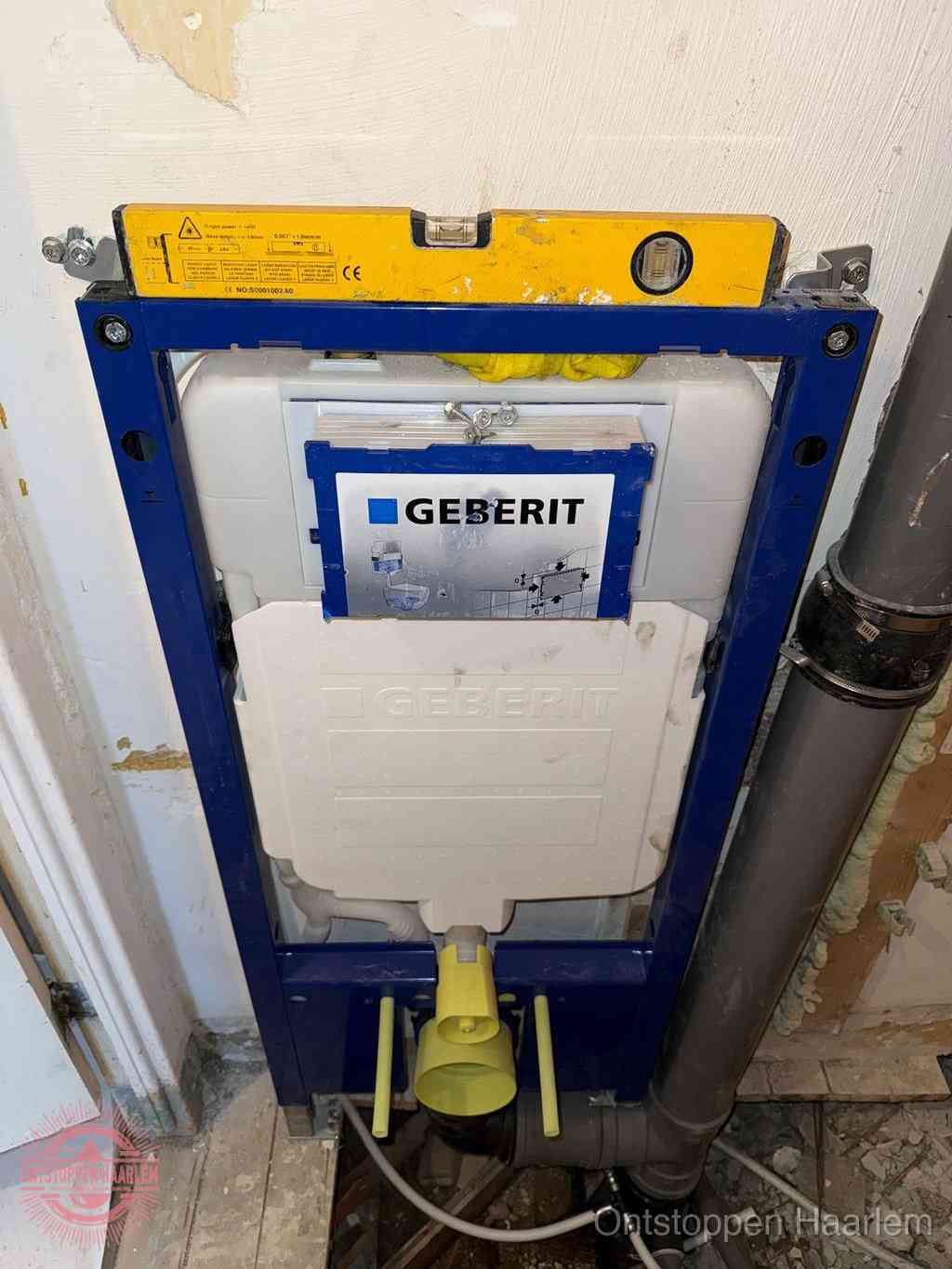 Een Geberit inbouwreservoir met frame voor een hangtoilet tegen de wand, met de afvoerbocht naar de vloer, kenmerkend voor een verstopt hangtoilet in Haarlem