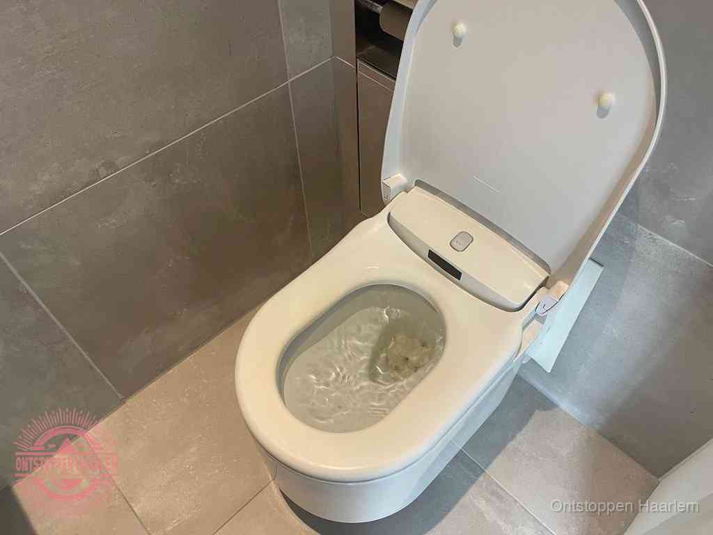 Een toiletpot vol troebel water met drijvend papier en restanten, de meest voorkomende oorzaak van een verstopte wc in Haarlem