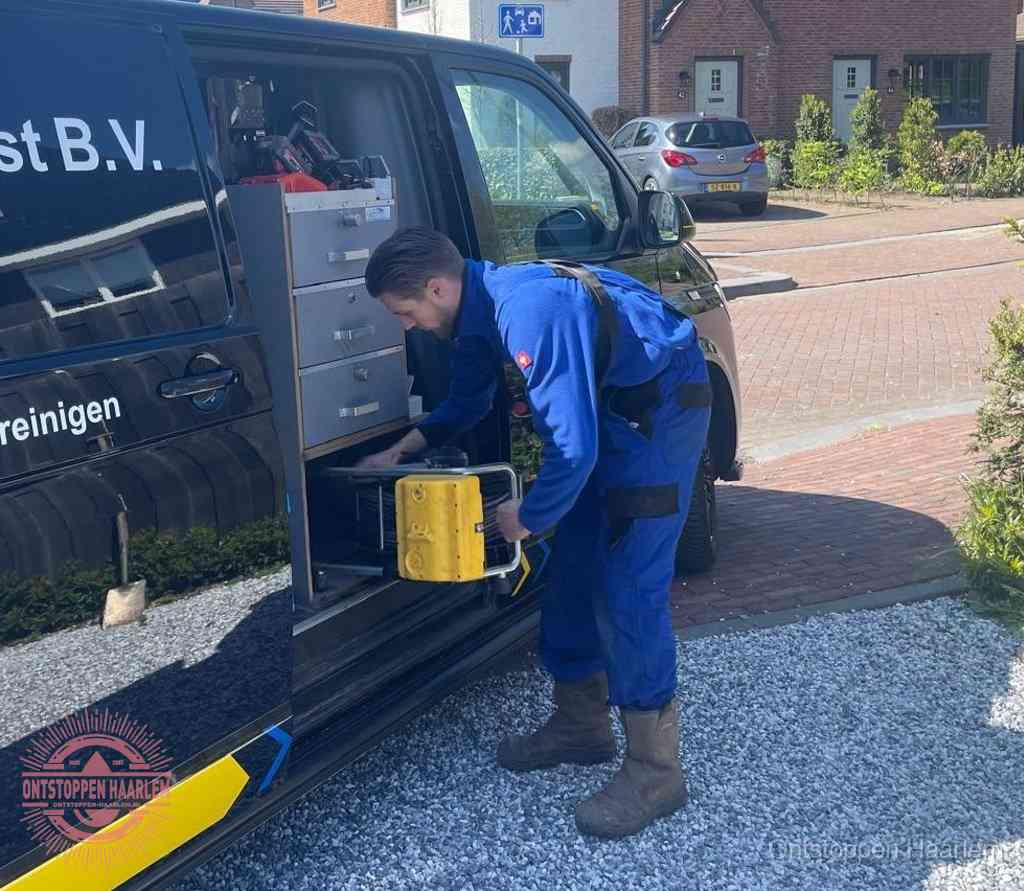 Een monteur pakt apparatuur uit de bedrijfsbus voor service aan huis, het moment om een professional in te schakelen in Haarlem