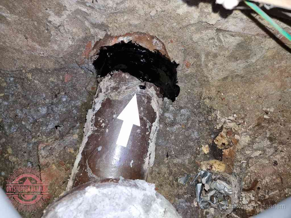 Een oude gres rioolbuis met een beschadigde koppeling onder de vloer, oorzaak van terugkerende structurele wc-problemen in Haarlem