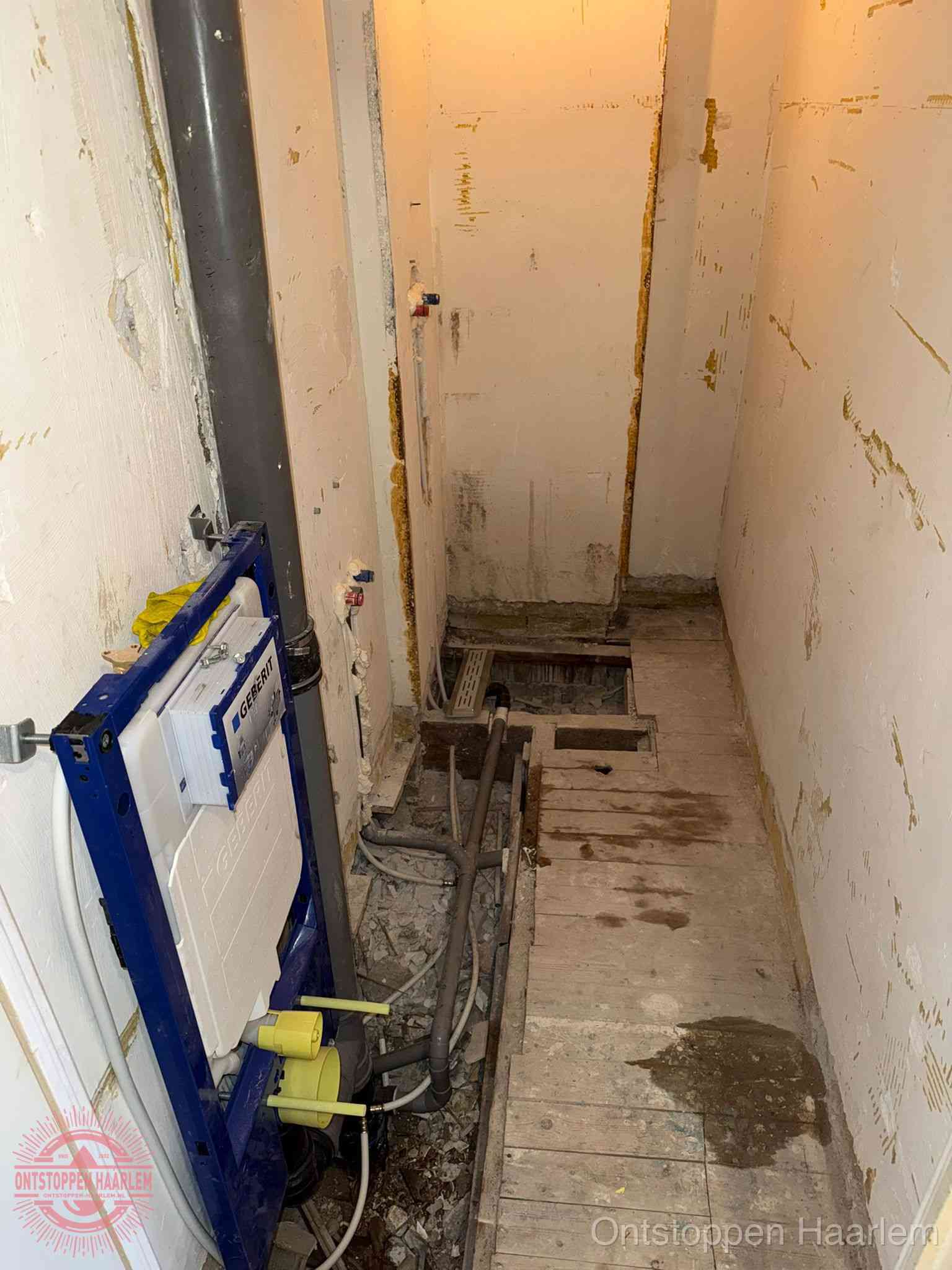 Een opgebroken toiletruimte tijdens renovatie met een Geberit inbouwreservoir en blootliggende oude afvoerleidingen, typisch voor oudere woningen in Haarlem